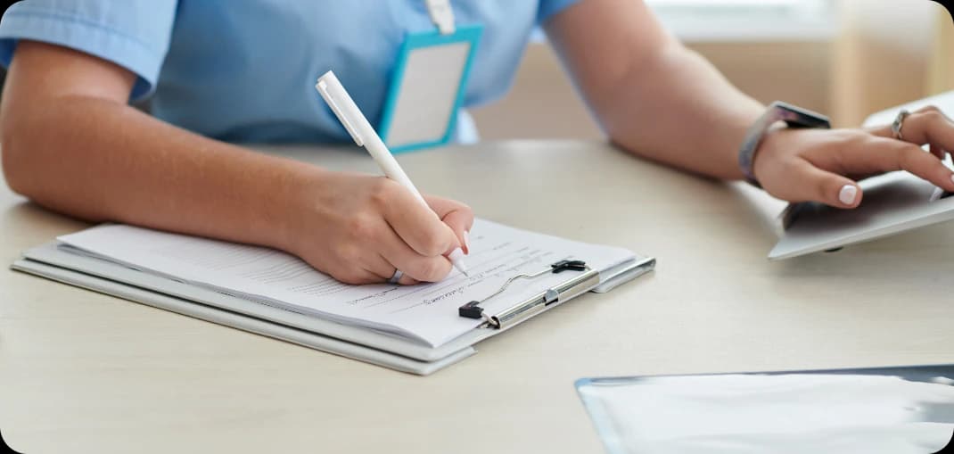 Healthcare professional completing a patient's record